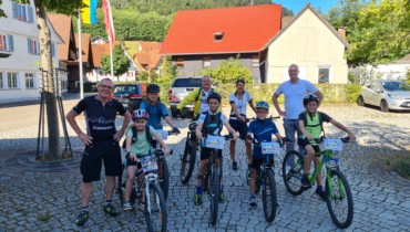 Kinder mit dem Fahrrad und Erwachsene vor dem Rathaus Schenkenzell