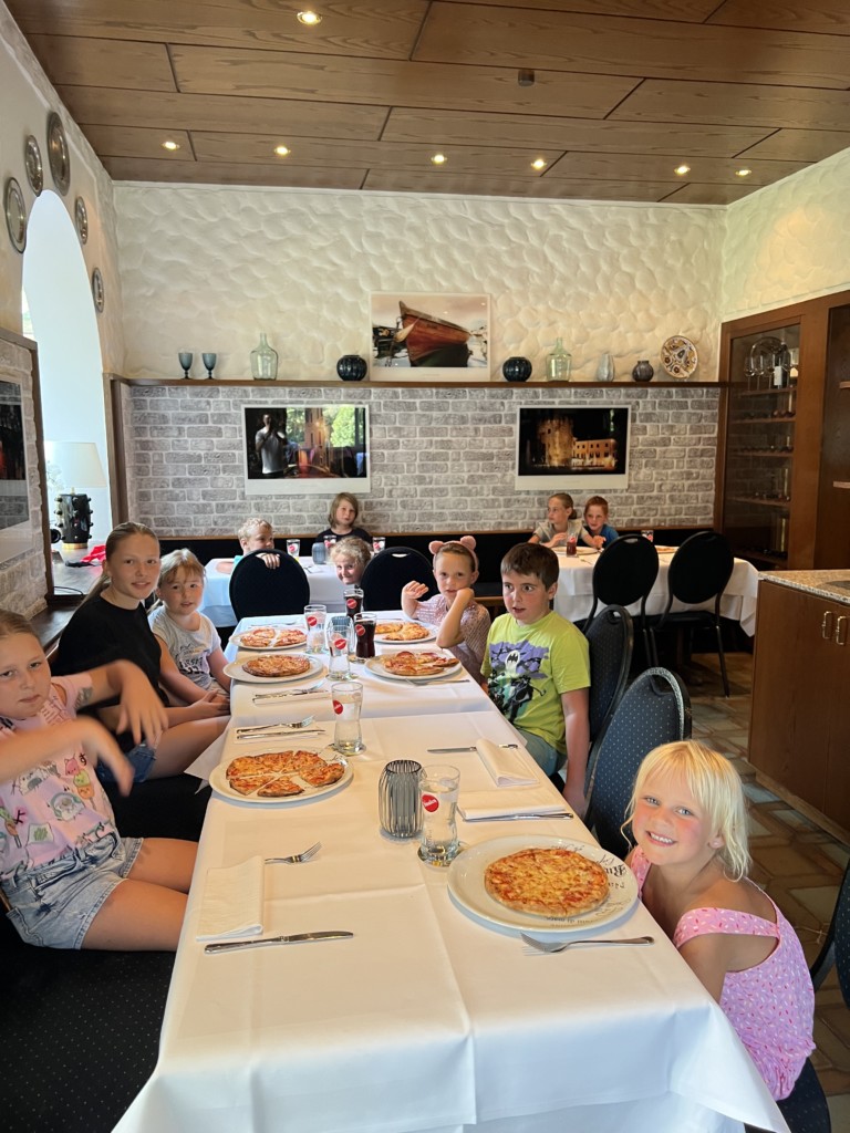 Kinder am Tisch mit selbstgemachter Pizza