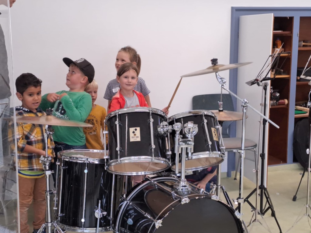 Kinder stehen hinter Schlagzeug
