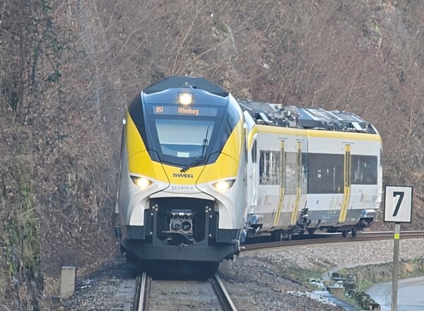 Bild von einem Zug auf Bahngleisen