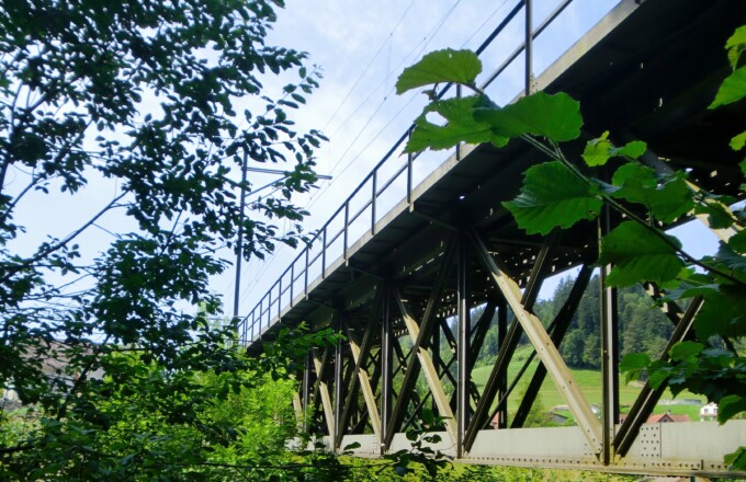 Bild von einer Eisenbahnbrücke zwischen Bäumen